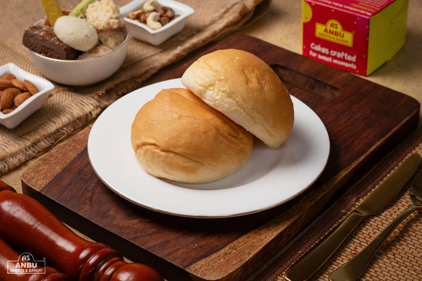 Two Buns on a white plate with ANBU branding in the background.