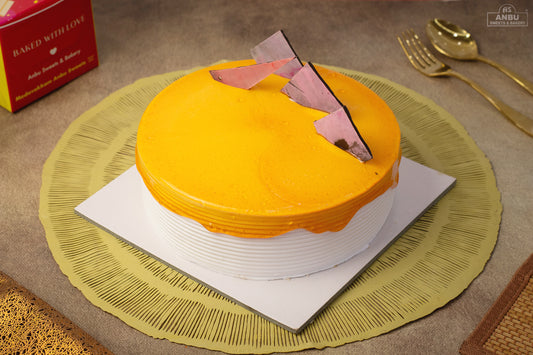 Yellow cake Butterscotch with a pink heart on a green placemat, surrounded by gold cutlery and a red box.