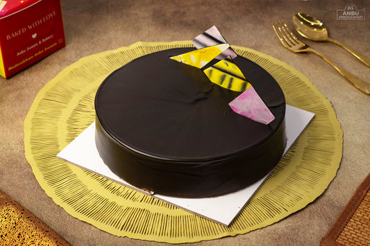 Chocolate Truffle cake with a slice cut out on a yellow place mat with a gold spoon and knife.