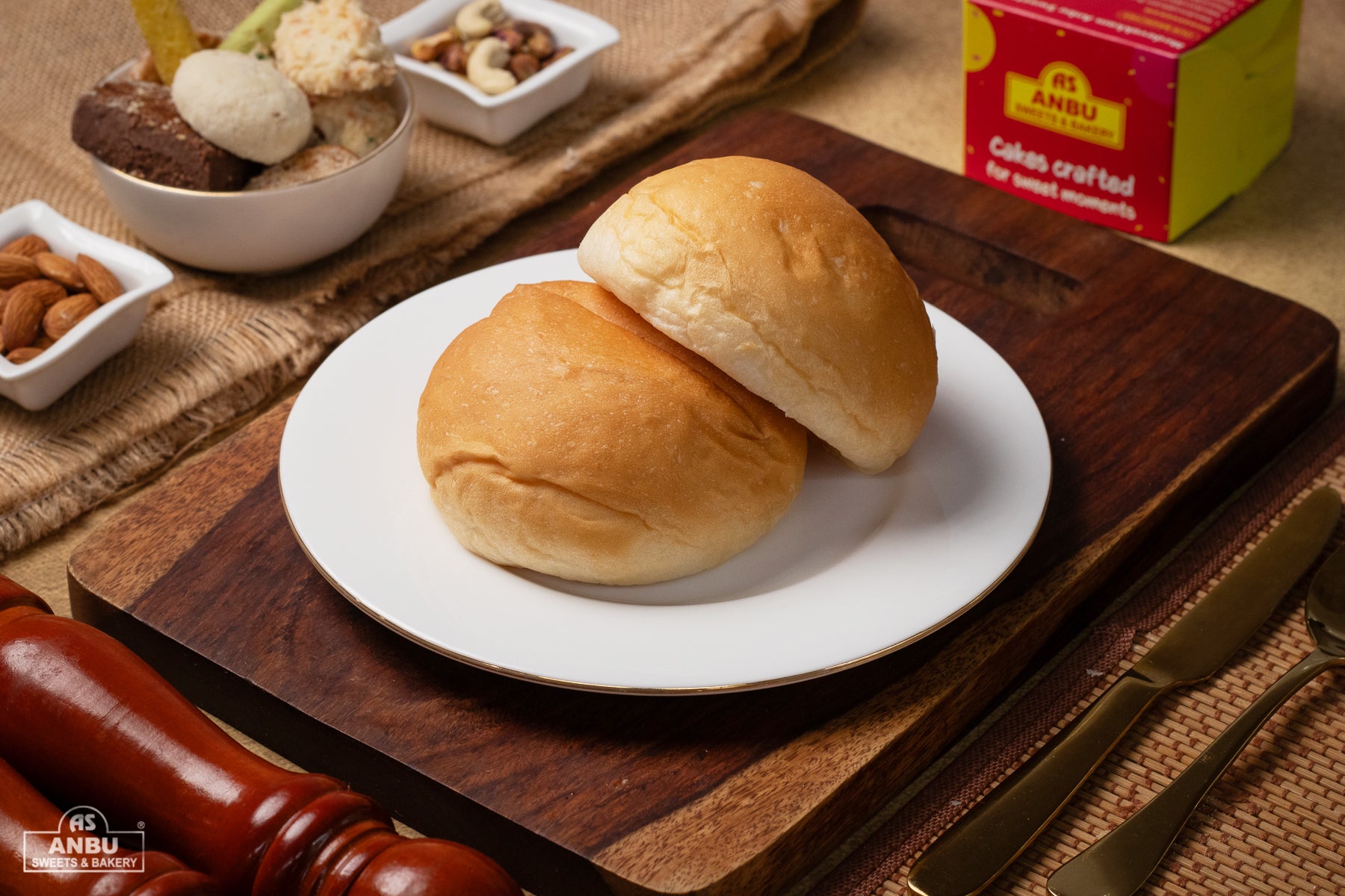 Two Buns on a white plate with ANBU branding in the background.